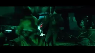 People in dimly lit room with large screen — John Wick: Chapter 4