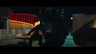Two people in park at night with red structure — John Wick: Chapter 4