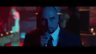 man in suit deep in thought with blue-red lights — John Wick