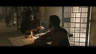 bearded man holding candle in dim room — Gladiator 2