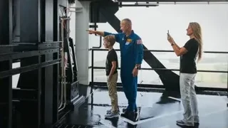 Man in space suit pointing with family — Elon Musk: Return to Space
