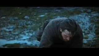 man kneeling deep in thought in muddy field — Batman