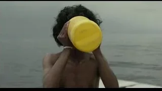 man holding yellow bucket on beach — Life of Pi