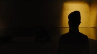 silhouette in dimly lit concrete room — Blade Runner 2049