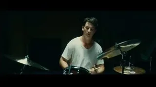 Young man playing drums in dimly lit room — Whiplash