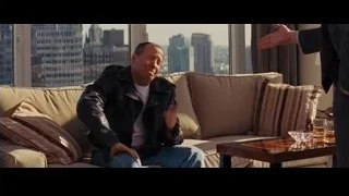 Man on couch gesturing, explaining in living room — The Wolf Of Wall Street