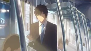 young man in suit standing on subway train — Your Name
