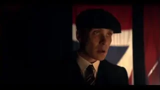 Man in suit by American flag looking surprised — Peaky Blinders