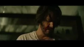 Man's face covered in blood in dark room — John Wick
