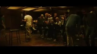Musicians playing instruments in dimly lit room — Whiplash