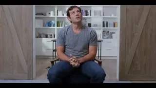 Man in t-shirt sitting on chair by bookshelf — The Social Dilemma
