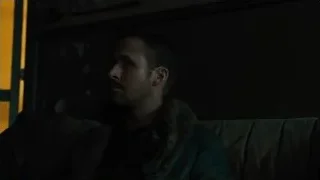 man with beard sitting on couch in dark room — Blade Runner 2049