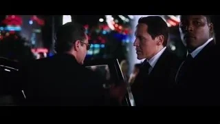 Three men in suits talking in neon lit room — Iron Man