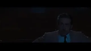 man in suit in dimly lit room — La La Land