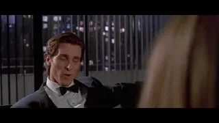 Man in tuxedo by window with city night view — American Psycho