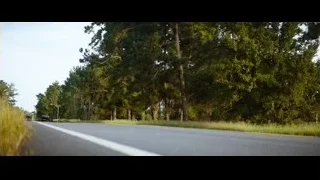 black sports car driving on rural road — Ford v Ferrari