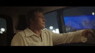 Man in white robe driving car at night — F1
