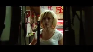 young woman holding gun in dim room — Lucy
