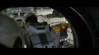 person in helmet looking out space station window — Interstellar