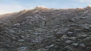 Person walking on rocky mountainous terrain — Your Name