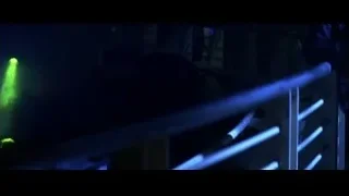 man with hand raised in dark green light — Batman: The Dark Knight