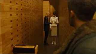 man and woman walking down corridor — Blade Runner 2049
