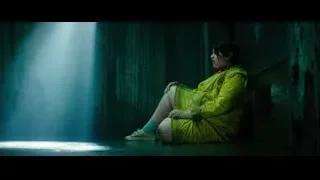 woman sitting in dark corridor with light beam — Deadpool 2
