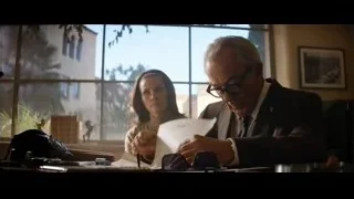 Elderly man and woman conversing at office desk — Ford v Ferrari