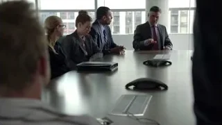 group of people in meeting room, man speaking — Suits