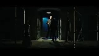 three men conversing in dimly lit hallway — John Wick