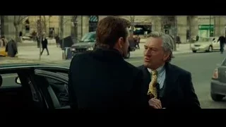 two men in suits on busy street — Limitless