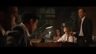 Men in suits conversing at desk — Ford v Ferrari