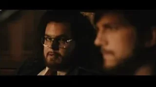 Two men sitting in dimly lit car — Jobs