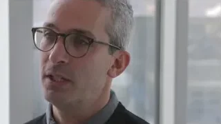Close-up of man with glasses and city skyline — Screened Out