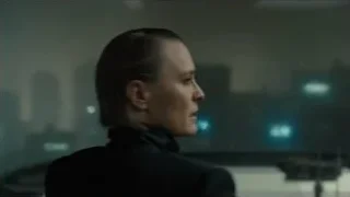 woman looking out window at city at night — Blade Runner 2049