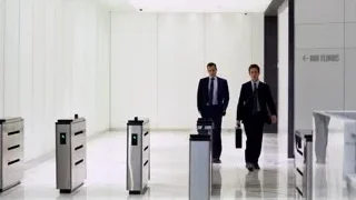 two men in suits walking through lobby — Suits