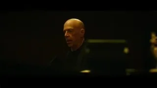 bald man deep in thought in dark room — Whiplash