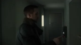 man pointing at device in dim hallway — Blade Runner 2049