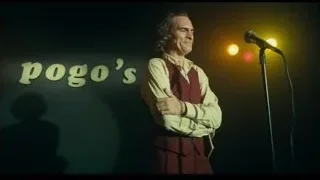 man singing on stage with microphone — Joker