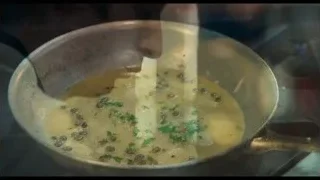 person's hand holding spoon over food — The Bear