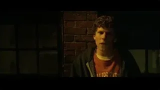 Young man in red t-shirt by brick wall — The Social Network