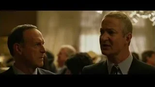 Two men in suits conversing at event — The Social Network
