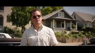 Man in white shirt in front of houses — Ford v Ferrari