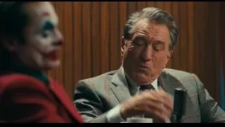 Joker at a table with a microphone — Joker