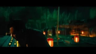 Man standing in park with red lanterns at night — John Wick: Chapter 4