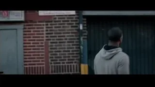 man smiling from old brick building window — Creed