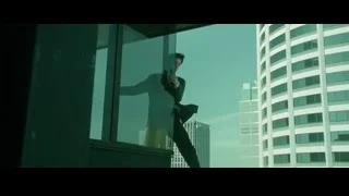 Man on balcony holding gun overlooking city — The Matrix