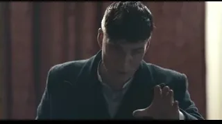 man gesturing in dark room with wooden wall — Peaky Blinders