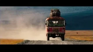 Red bus driving on dirt road — The Secret Life of Walter Mitty