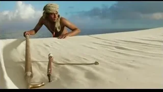 Man in turban pulling rope on sand dune — Life of Pi